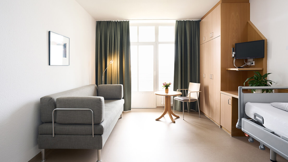 1_1_B2B_Bettsofa_Contract_Swiss_Plus_Raum_mit_Blumen_2_Schmieder_Kliniken_Fotograf_Samuel_Koeppel 1_1_B2B_Bettsofa_Contract_Swiss_Plus_Raum_mit_Blumen_2_Schmieder_Kliniken_Fotograf_Samuel_Koeppel